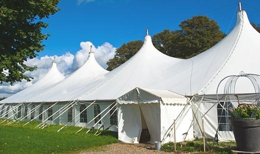 tall green portable restrooms assembled at a music festival, contributing to an organized and sanitary environment for guests in Southport